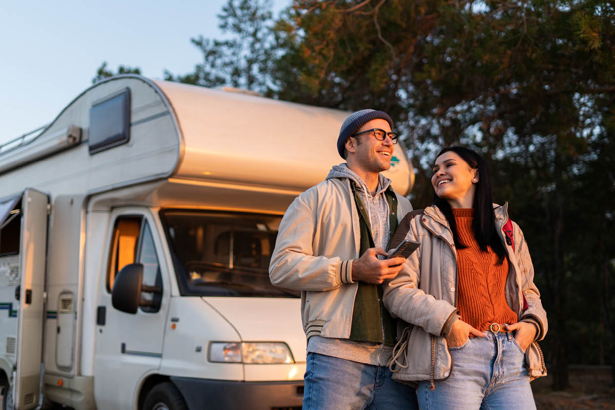 Zu sehen sind zwei Personen vor einem Wohnmobil